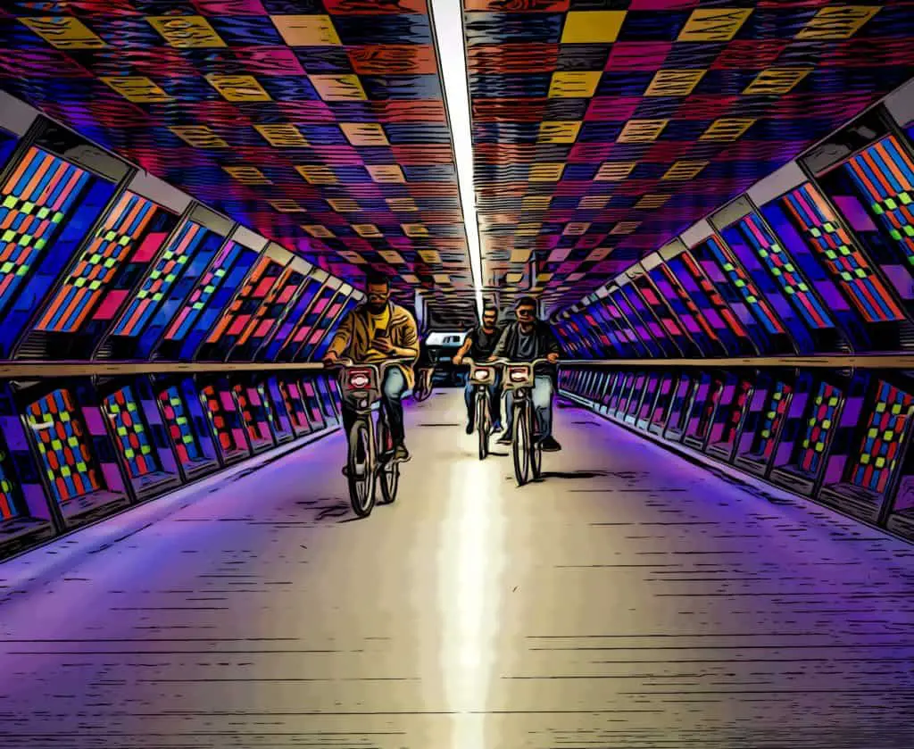cyclists ride through crossrail place bridge in canary wharf